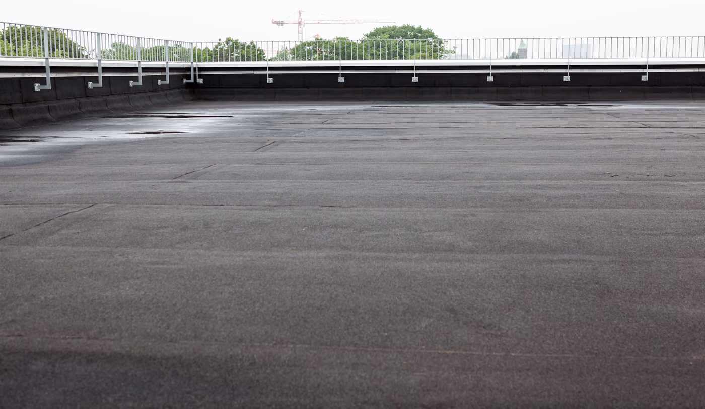 a flat roof with roofing and fencing