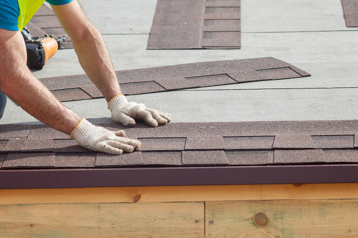 Roofer installing roof shingles during a flat roof repair by DSY Roofing & Building Contractors