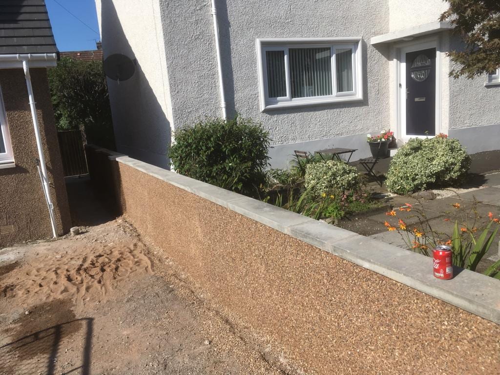 Garden wall freshly finished in pebble dash roughcast with concrete coping