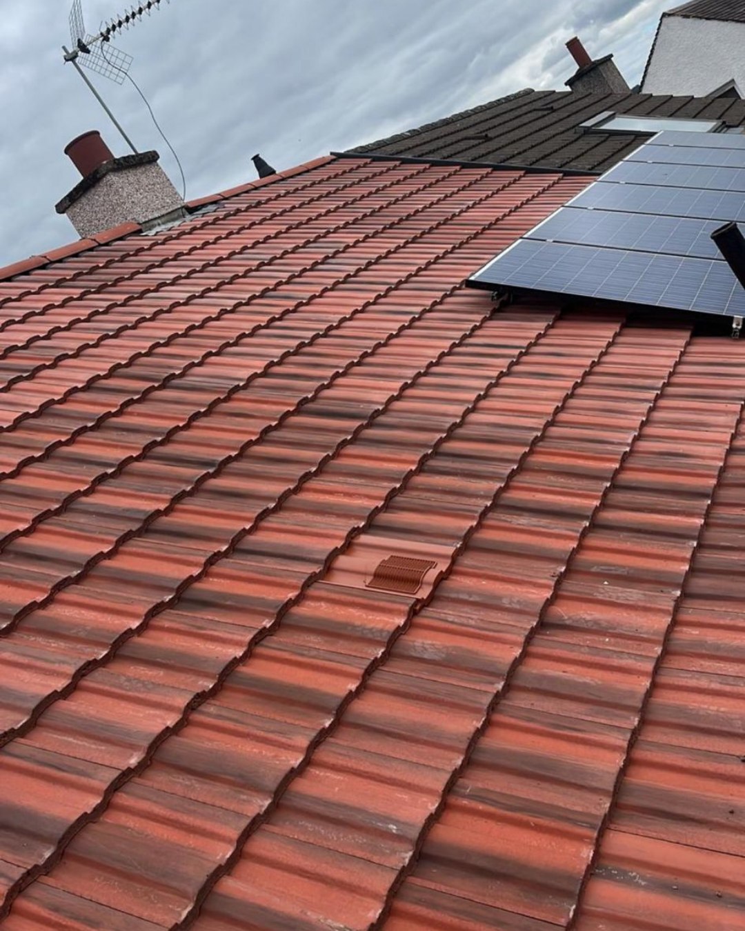 Close-up of a freshly retiled roof with solar panels installed