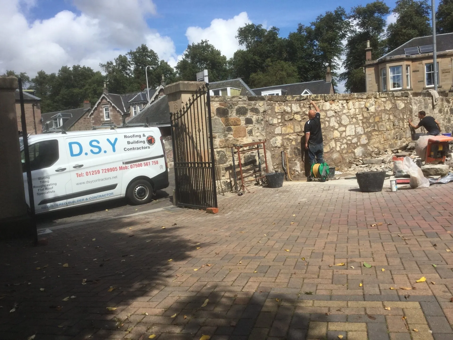 DSY Roofing van parked outside a stone wall being prepared for expert masonry restoration