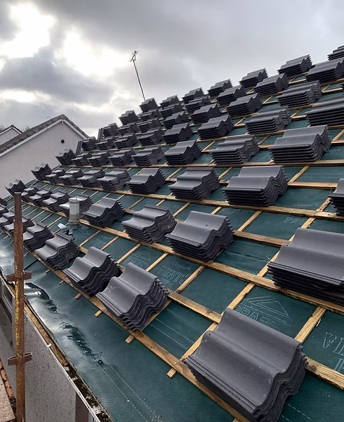 Roof tiles stacked on battens during a DSY roofing project